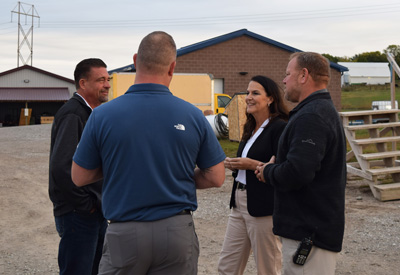 Lieutenant Governor Cournoyer discussing the home building program with key program representatives at the build site